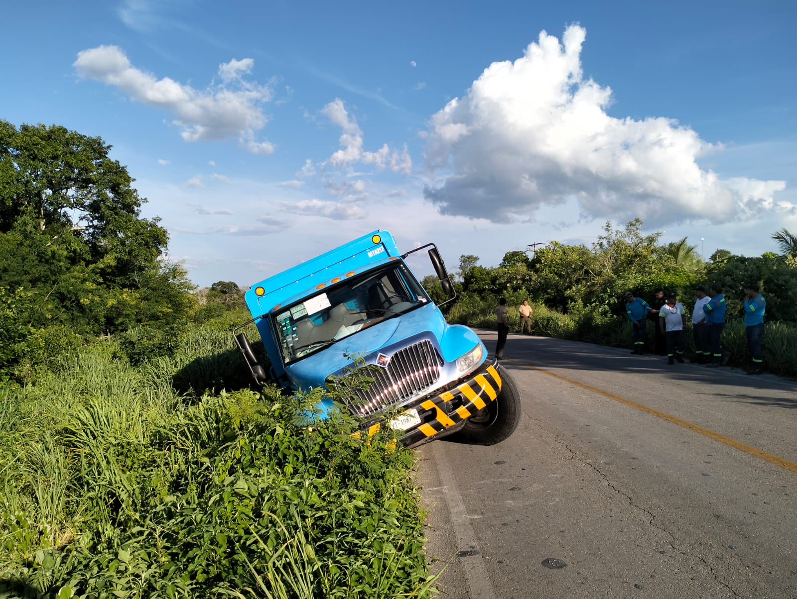 Un camión repartidor de agua sale en una curva en el periférico de Motul