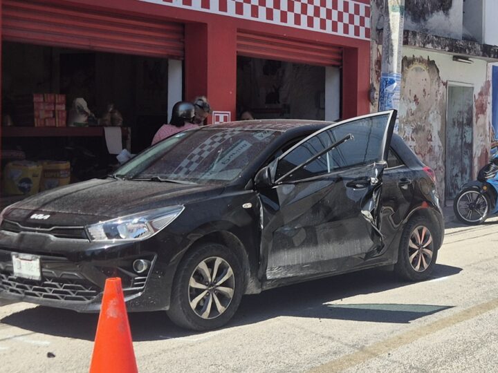 Un autobús de trasporte de personal casi le arranca la pueta a un Kia en calles de Dzidzantún