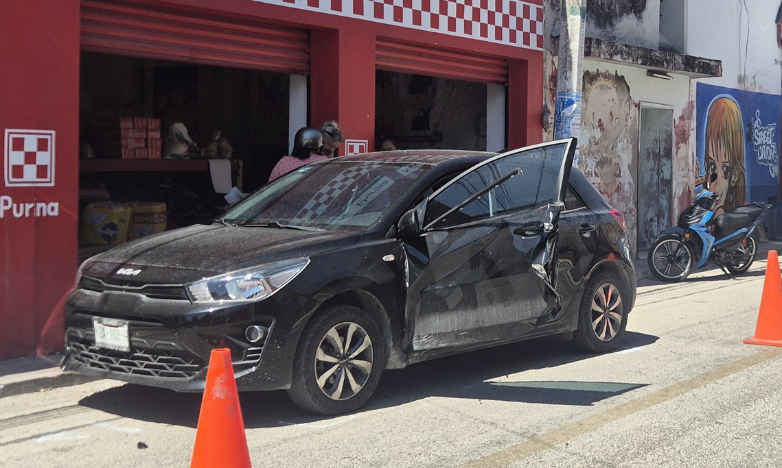 Un autobús de trasporte de personal casi le arranca la pueta a un Kia en calles de Dzidzantún